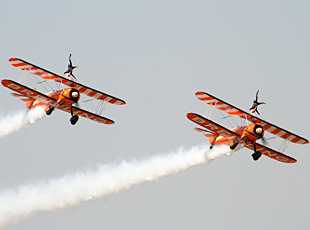 Wingwalkers demonstrating their acrobatic skills in midair