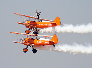 Wingwalkers demonstrating their acrobatic skills in midair