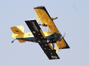 Catwalk Aerobatic Team members perform aerial stunts atop Boeing Stearman biplane